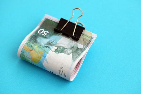 Israel New Shekels banknotes on blue background. The current Israel money bills lies on blue in big...