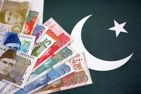 Pakistan rupees banknotes on Pakistani flag background. The current Pakistan money bills lies on banner in big amount. The concept of economics and business in Pakistanの写真素材