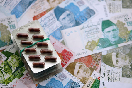 Pakistan rupees banknotes and medicine pills. The current Pakistan money bills and drugs lie on the table in a big amount. The concept of medicine and pharmacy in Pakistanの写真素材