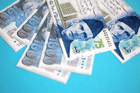 Pakistan rupees banknotes on blue background. The current Pakistan money bills lies on table in big amount. The concept of business and investment in Pakistanの写真素材