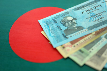 Bangladeshi taka money bills in big amount lies on Bangladesh flag close up. Finance and banking conceptの写真素材