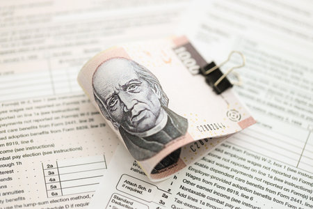 Mexican pesos money bills in big amount lies on table with tax forms close up. Accounting and...