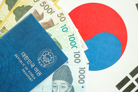 South Korean won money bills in big amount and passport lies on South Korea flag close up. Finance and banking conceptの写真素材