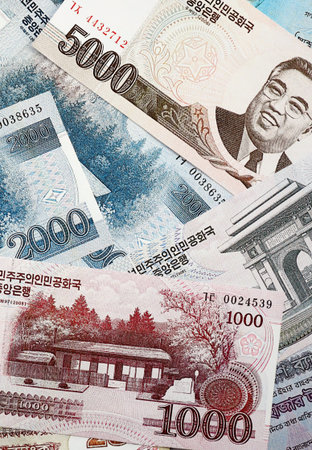 North Korean won money bills in big amount lies on white color table close up. Finance and banking conceptの写真素材