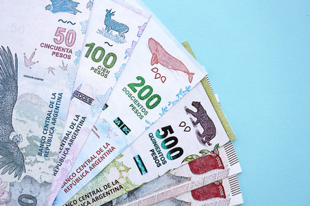 Argentine pesos money bills in big amount lies on teal color table close up. Finance and banking conceptの写真素材