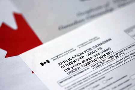 Canadian certificate of citizenship and application on Canadian flag close upの写真素材
