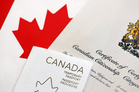 Canadian temporary passport and certificate of citizenship lies on flag close upの写真素材