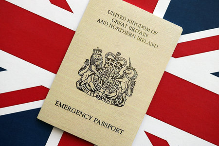 British emergency passport. Yellow color temporary document on flag background close upの写真素材