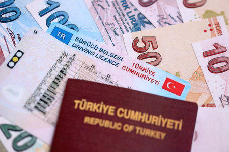 Turkiye driving permit concept. Driver license with passport and turkish liras money bills close upの写真素材