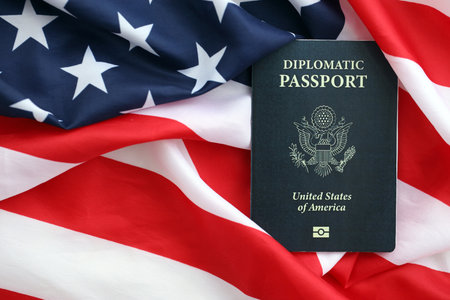 United States diplomatic passport book on US flag close up. Travel document on official banner photoの写真素材