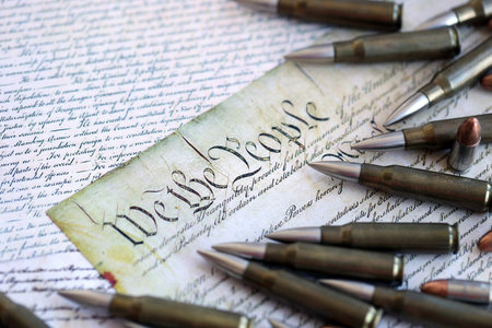Gun control and second amendment in America concept. Bullets on american constitution with close up...