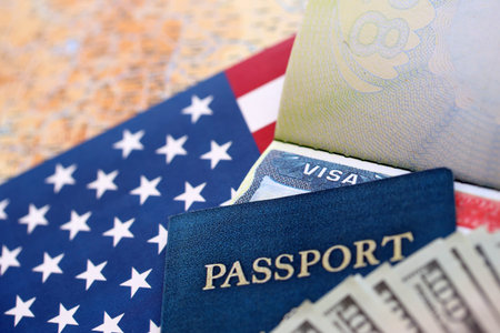 Passport and US Visa for immigration with many money bills close up on USA flag. Concept of immigration visa and taxes for travelの写真素材