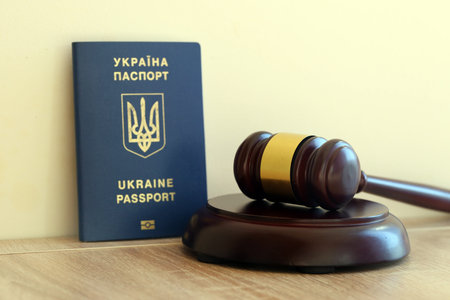Judge mallet and ukrainian passport on brown background. Passport Of Ukraine. Obtain citizenshipの写真素材