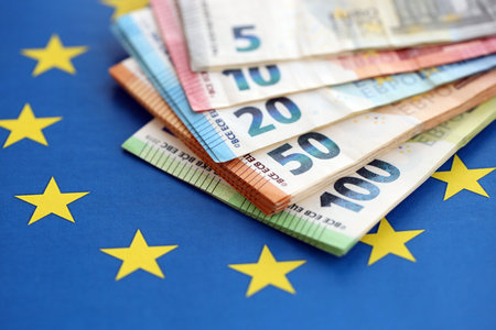 European eur currency money bills on Euro union blue flag close up. Concept of business and economics in Europeの写真素材