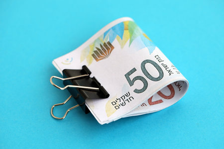 Israel New Shekels banknotes on blue background. The current Israel money bills lies on blue in big...
