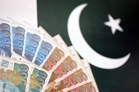 Pakistan rupees banknotes on Pakistani flag background. The current Pakistan money bills lies on banner in big amount. The concept of economics and business in Pakistanの写真素材