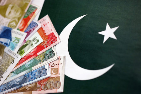 Pakistan rupees banknotes on Pakistani flag background. The current Pakistan money bills lies on banner in big amount. The concept of economics and business in Pakistanの写真素材