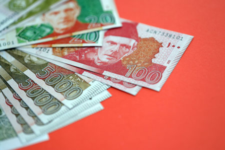Pakistan rupees banknotes on red background. The current Pakistan money bills lies on table in big amount. The concept of business and investment in Pakistanの写真素材