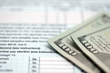 Hundred dollar bills and 1040 individual income tax return form blank close up. Few usd notes and united states tax blank. Concept of taxpaying and accounting in United Statesの写真素材