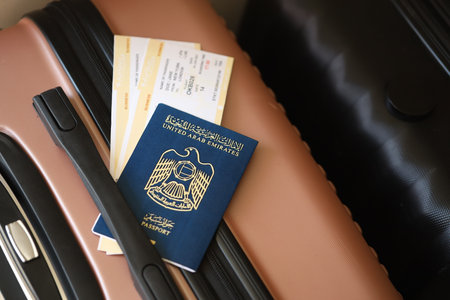 United Arab Emirates UAE passport with tickets lies on touristic suitcase close up in airport waiting hall. Travel worldwide and international tourism conceptの写真素材