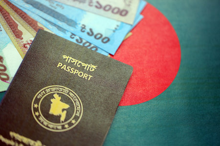 Bangladeshi taka money bills in big amount and passport lies on Bangladesh flag close up. Finance and banking conceptの写真素材