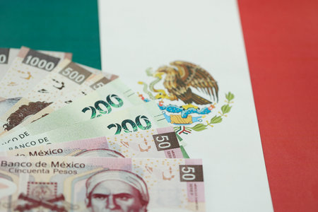 Mexican pesos money bills in big amount lies on Mexico flag close up. Finance and banking conceptの写真素材