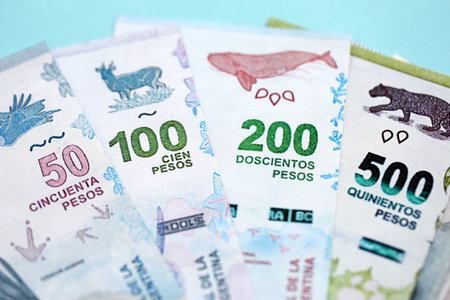 Argentine pesos money bills in big amount lies on teal color table close up. Finance and banking conceptの写真素材