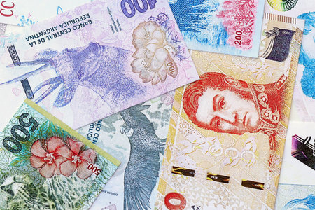 Argentine pesos money bills in big amount lies on white table close up. Finance and banking concept