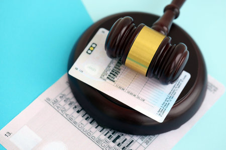 Generic driving license and judge hammer on blue background close upの写真素材