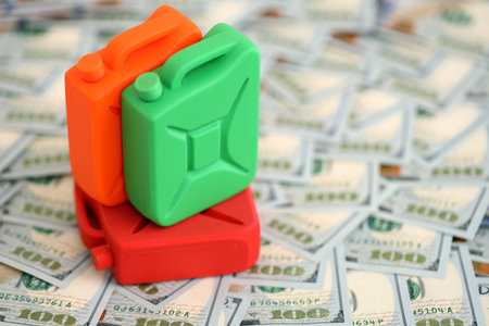 Petroleum canister lies on big amount of dollar bills. Concept of petrol prices in United Statesの写真素材