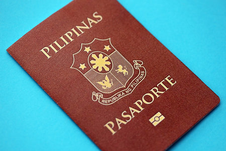 Philippines passport book on light blue paper background close up. Travel document on blue surfaceの写真素材