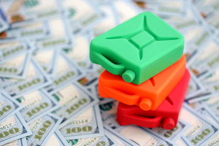 Gasoline canister lies on big amount of dollar bills. Concept of petrol prices in United Statesの写真素材