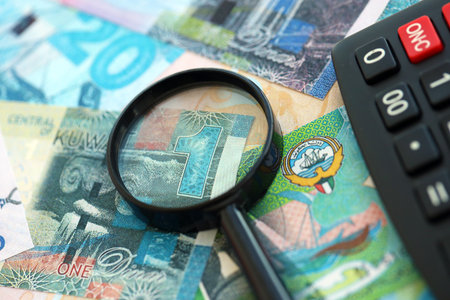Kuwaiti dinar currency money bills and calculator with magnifying glass close up. The concept of...