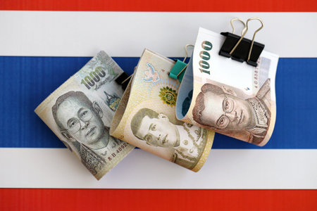 Thai baht currency money bills lies on flag close up. The concept of business and investment