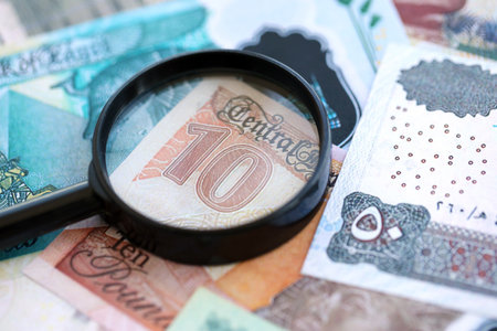Egyptian pound currency money bills and magnifying glass close up. The concept of financial monitoring and taxationの写真素材