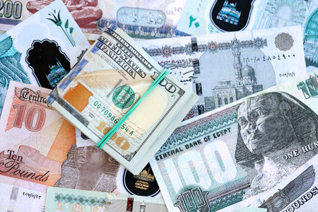 Egyptian pound currency money bills and bunch of us dollar banknotes close up. The concept of...
