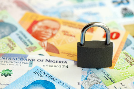Nigerian naira currency money bills and padlock close up. The concept of sanctions and financial...