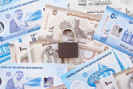 United Arab Emirates dirham currency money bills and padlock close up. The concept of sanctions and financial safetyの写真素材