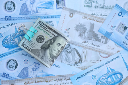 United Arab Emirates dirham currency money bills and bunch of us dollar banknotes close up. The...