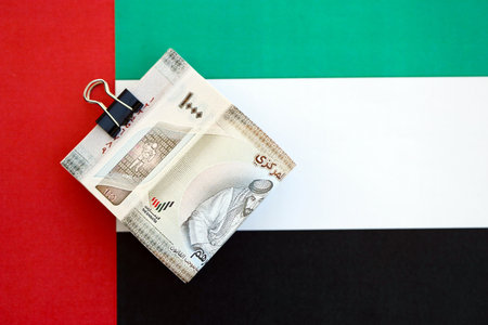 United Arab Emirates dirham currency money bills lies on flag close up. The concept of business and...