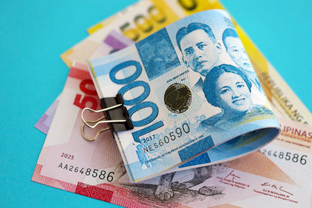 Philippines peso money bills in big amount close up on blue. Finance and banking concept