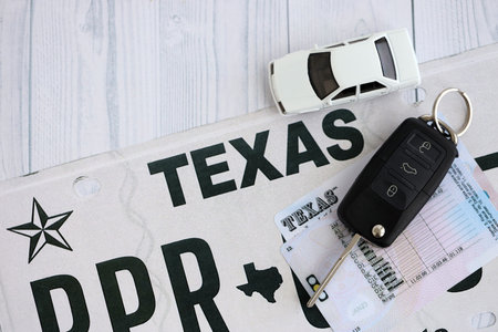 Remote control car keys on Texas license plate with driver license. Concept of driving in Texas....