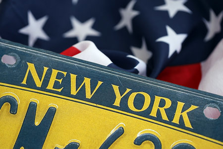 USA state of New York license plate on US flag. Concept of driving in New York. Reaching a driving permitの写真素材