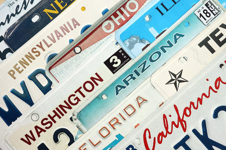 Old US car license plates with various state names. Concept of driving in United States. Reaching a car registrationの写真素材