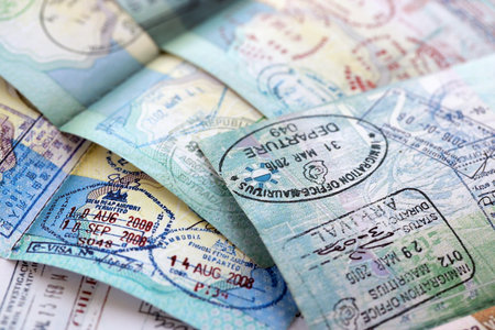 Many open passport pages with lots of visas and entrance stamps from various countries passport control. Concept of travel and tourism worldwideの写真素材