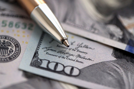 One hundred US dollar bills and silver pen close up. Concept of business calculating and accounting in United Statesの写真素材