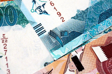 Qatari riyal money bills banknotes lies in big pile on table close up. Concept of finances and...