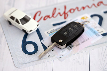 Remote control car keys on California license plate with driver license. Concept of driving in California. Reaching a driving permitの写真素材