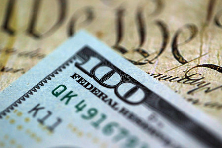 One hundred US dollar bills and United States Constitution page fragment. Concept of lawsuit in...