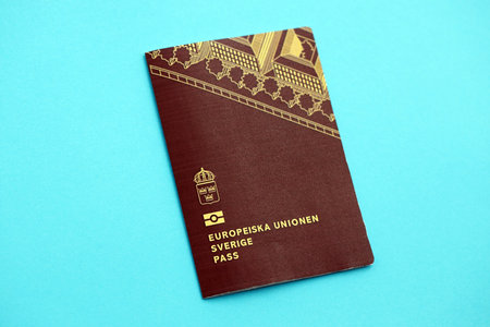 Swedish biometrical passport on light blue table background. Concept of citizenship of Swedenの写真素材